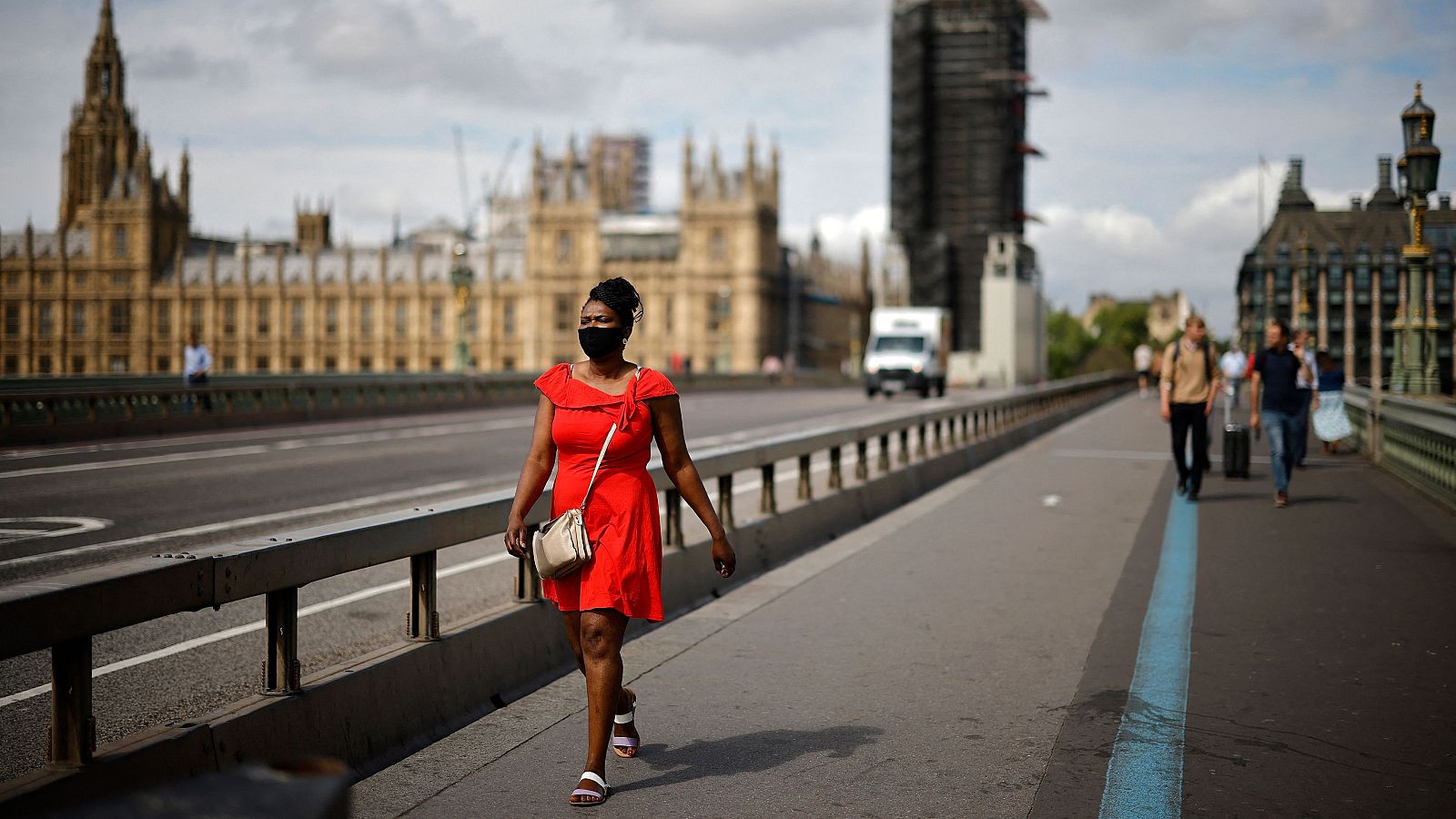 Una mujer cruza caminando el Puente de Westminster, en Londres.