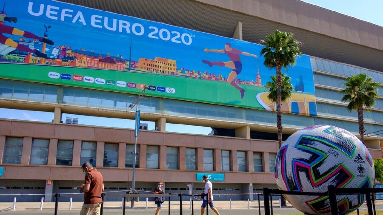 Aficionados junto a una réplica del balón del torneo en el estadio de La Cartuja de Sevilla