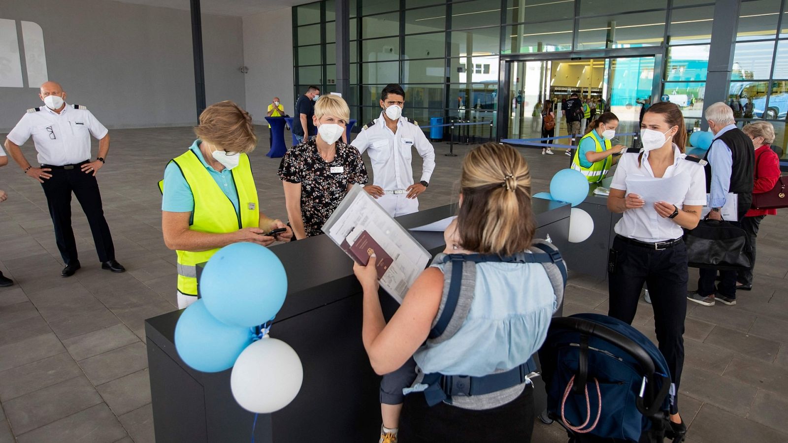 Una trabajadora controla la documentación de una pasajera de un crucero