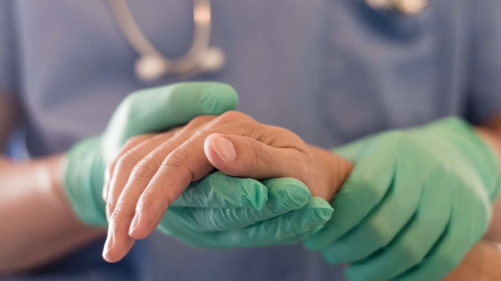 Un médico sostiene la mano de su paciente