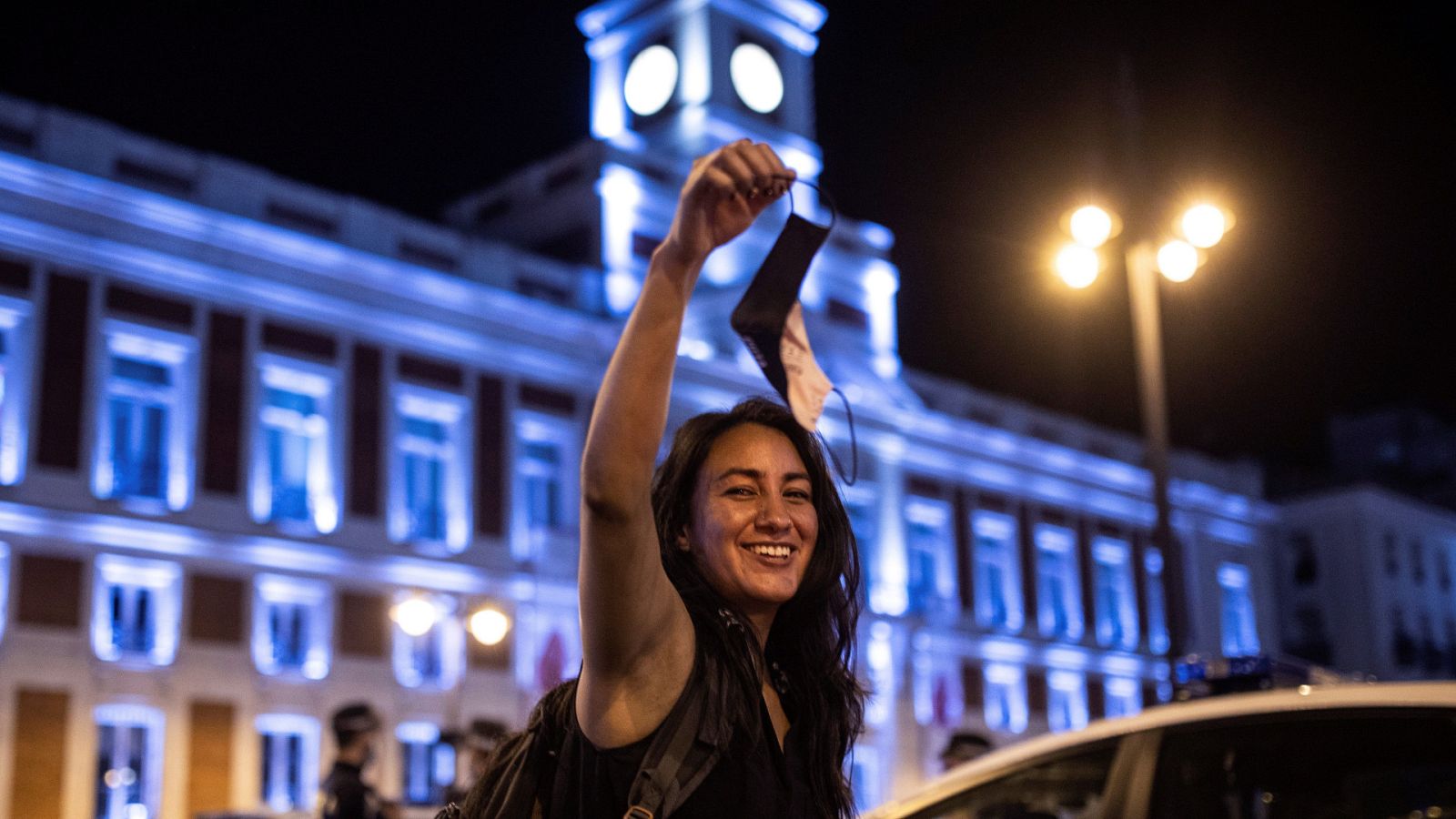 Una chica celebra el fin del uso obligatorio de la mascarilla en espacios abiertos en la Puerta del Sol, en Madrid