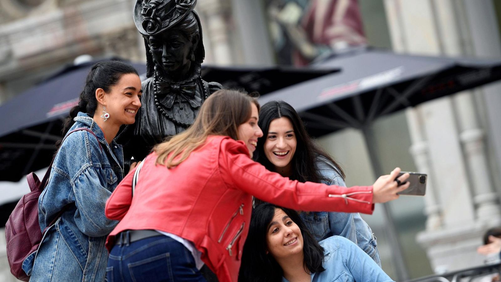 Turistas sin mascarilla se toman una fotografía en Oviedo