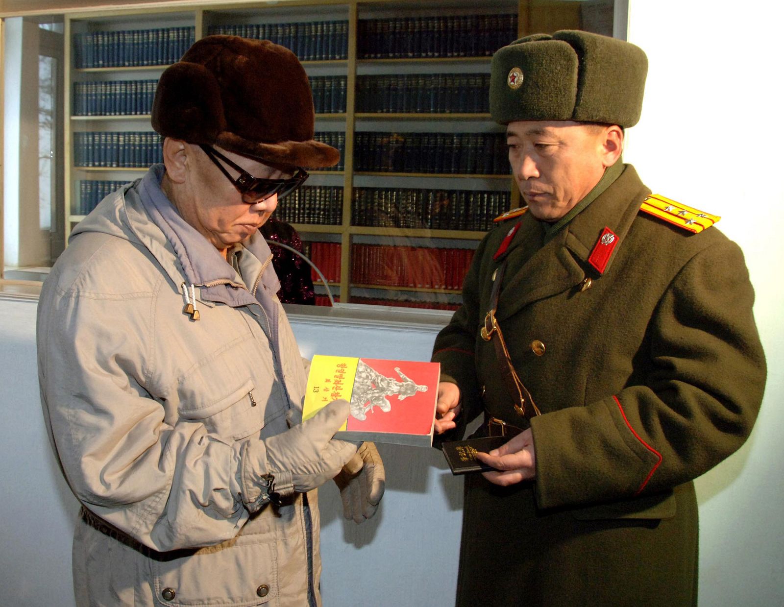 North Korean leader Kim Jong-il looks at a book as he visits the 323 military unit at an undisclosed place in North Korea in this picture from KCNA