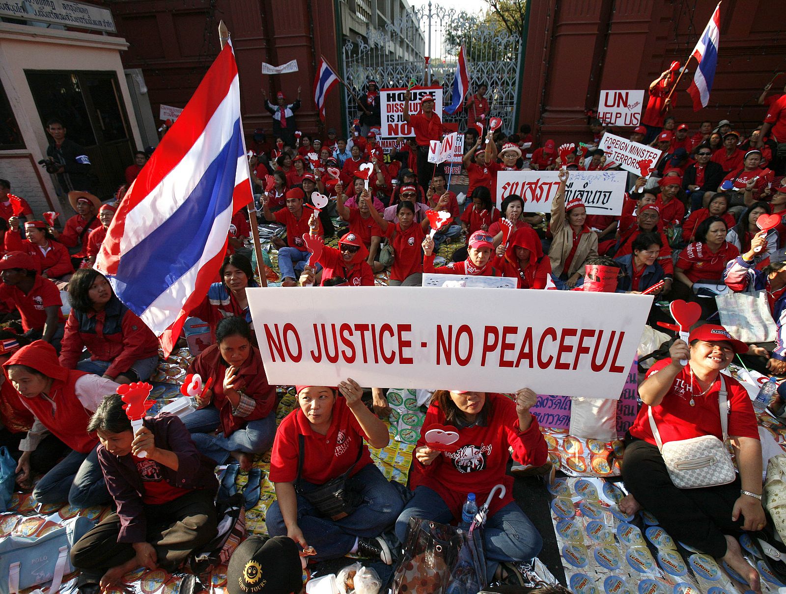 Supporters of former prime minister Thaksin Shinawatra hold a banner during a protest against the government outside Parliament in Bangkok