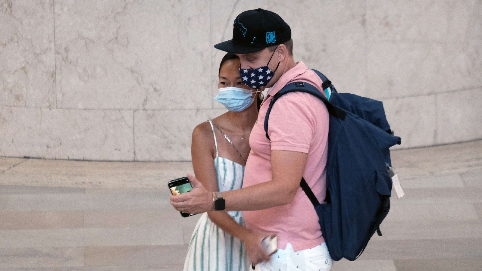 Una pareja posa con mascarilla para una foto en la Terminal Grand Central de Nueva York
