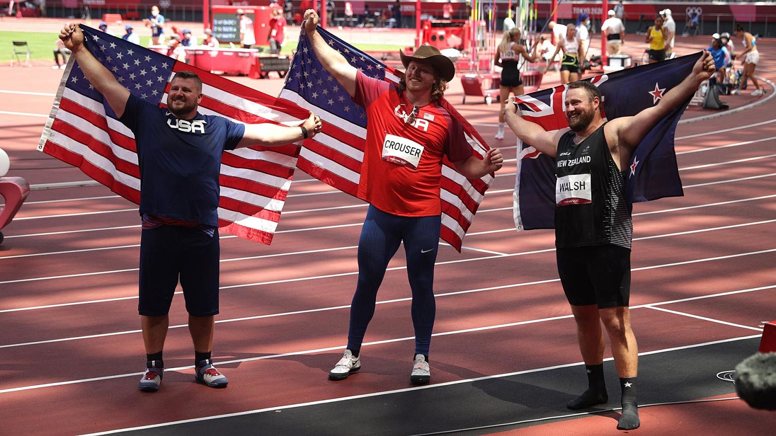 Los estadounidenses Ryan Crouser, oro, y Joe Kovacs, plata, celebran su éxito en Tokyo 2020 junto al ganador del bronce, el neozelandésb Tomas Walsh