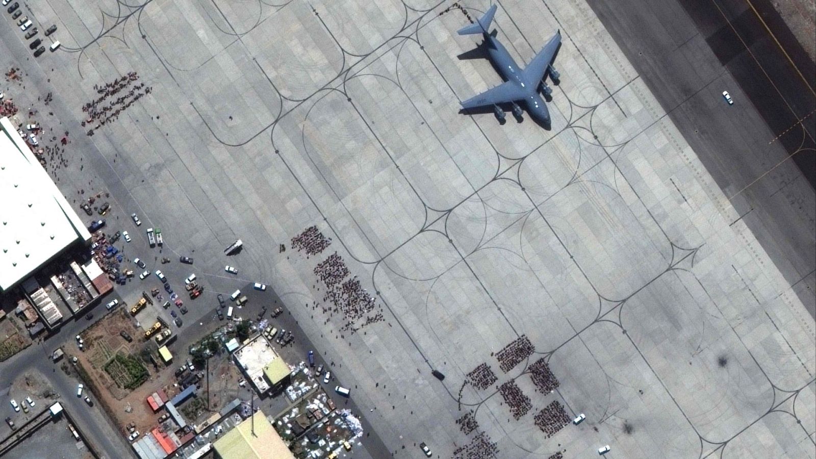 Grupos de afganos esperan para embarcar en un avión