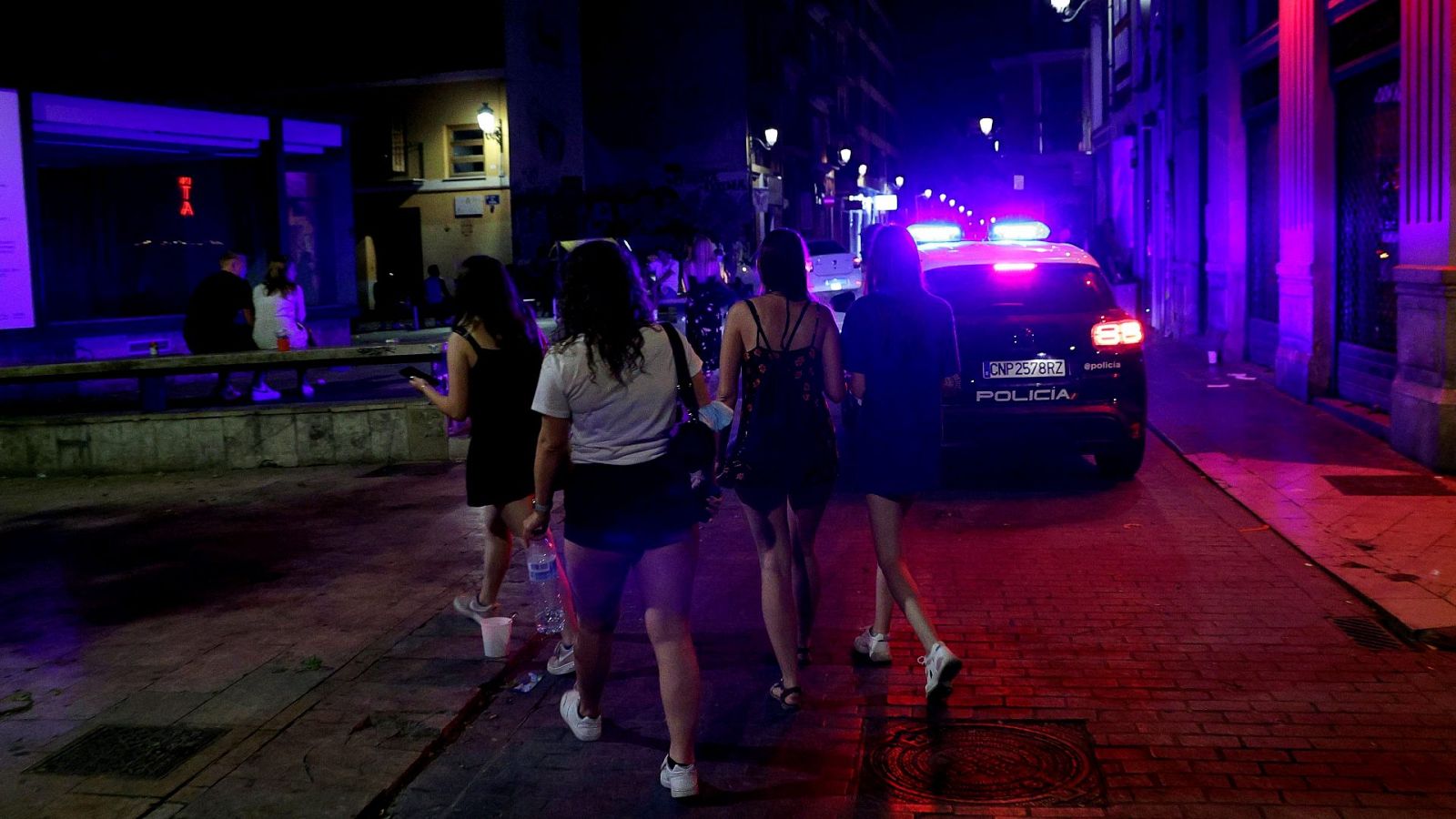 Un coche de policía patrulla las calles por la noche