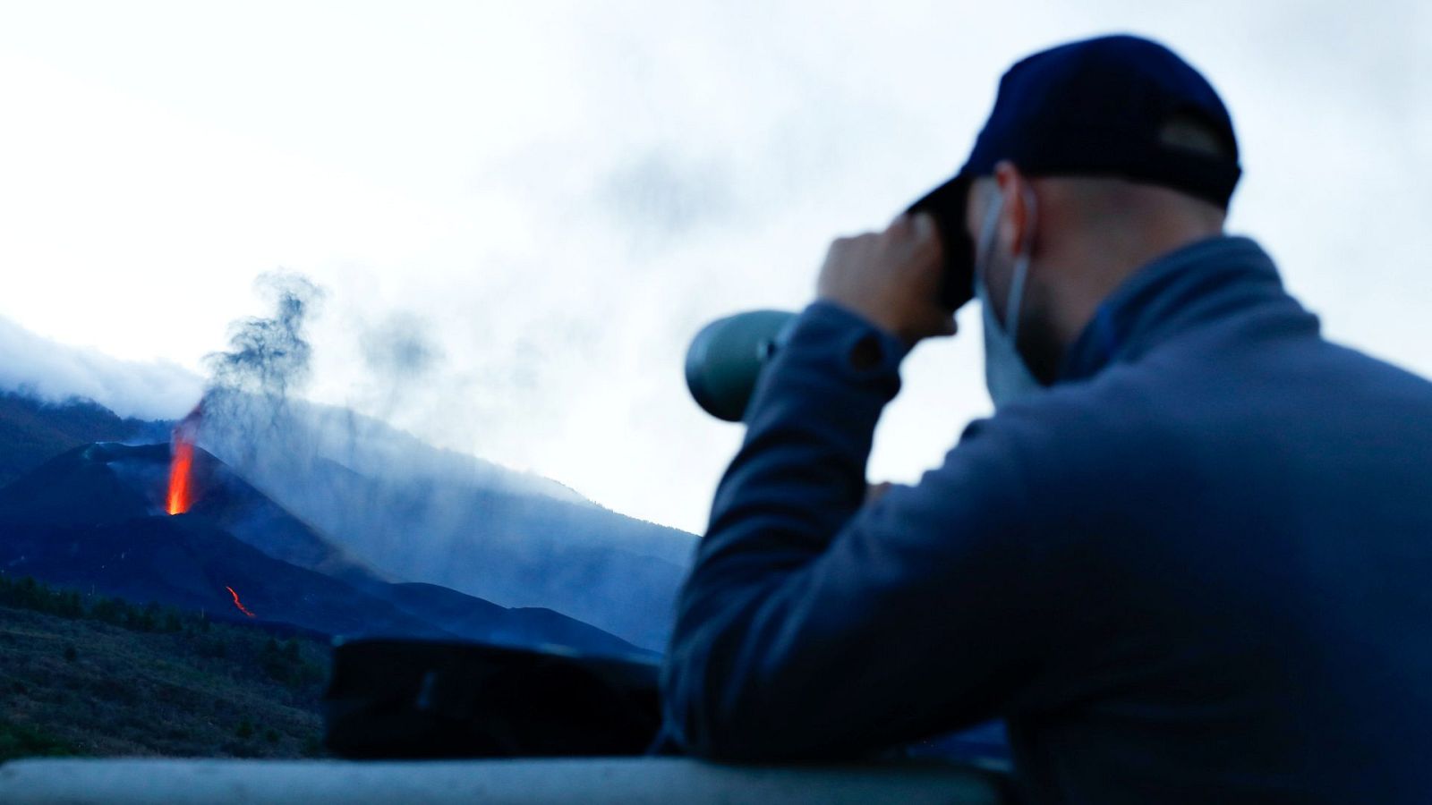 Un hombre observa el volcán de Cumbre Vieja con sus prismáticos desde el mirador de Tajuya