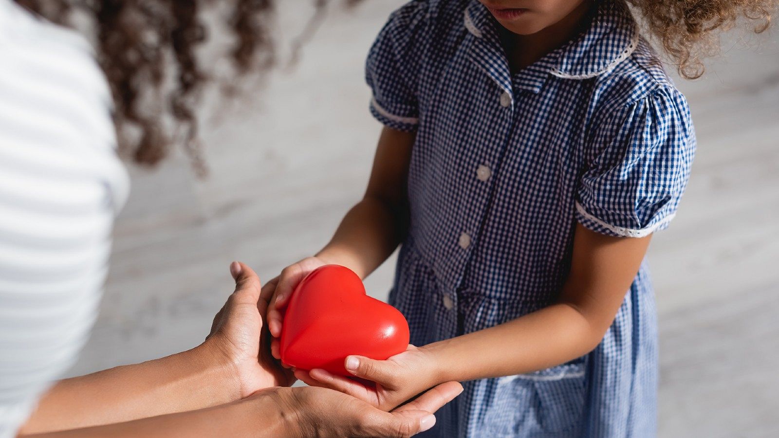 Una niña sostiene entre sus manos un corazón de juguete, en una imagen de archivo