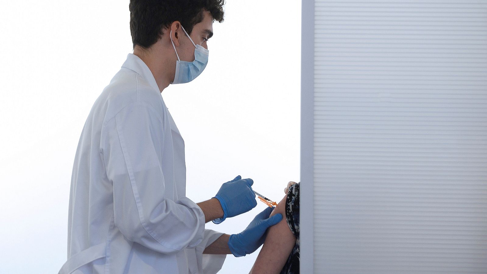 Un sanitario inocula la tercera dosis de Pfizer a una persona en Valladolid.