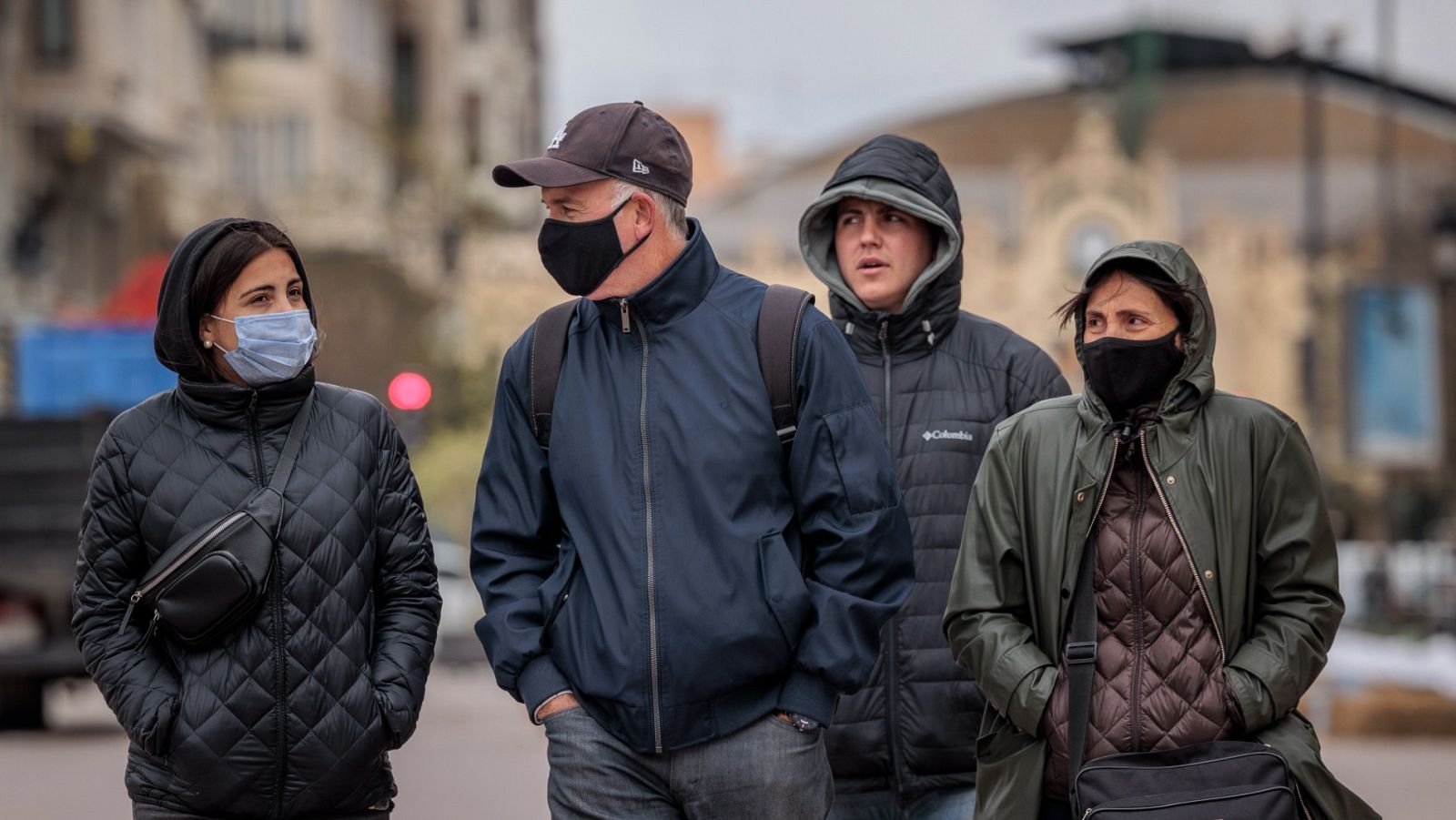 Varias personas pasean bien abrigadas y con mascarillas por el centro de Valencia, este lunes
