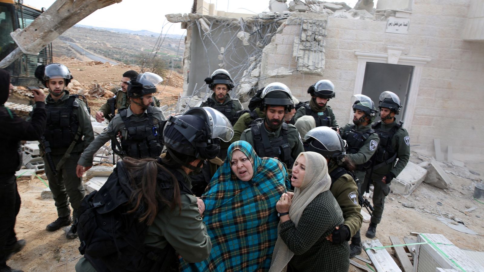 Mujeres palestinas se enfrentan a soldados israelíes contra la demolición de su casa