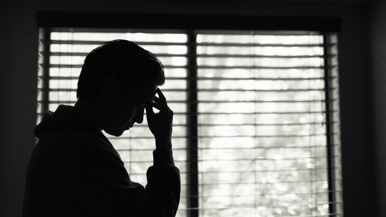 Un hombre joven se despierta preocupado en su habitación