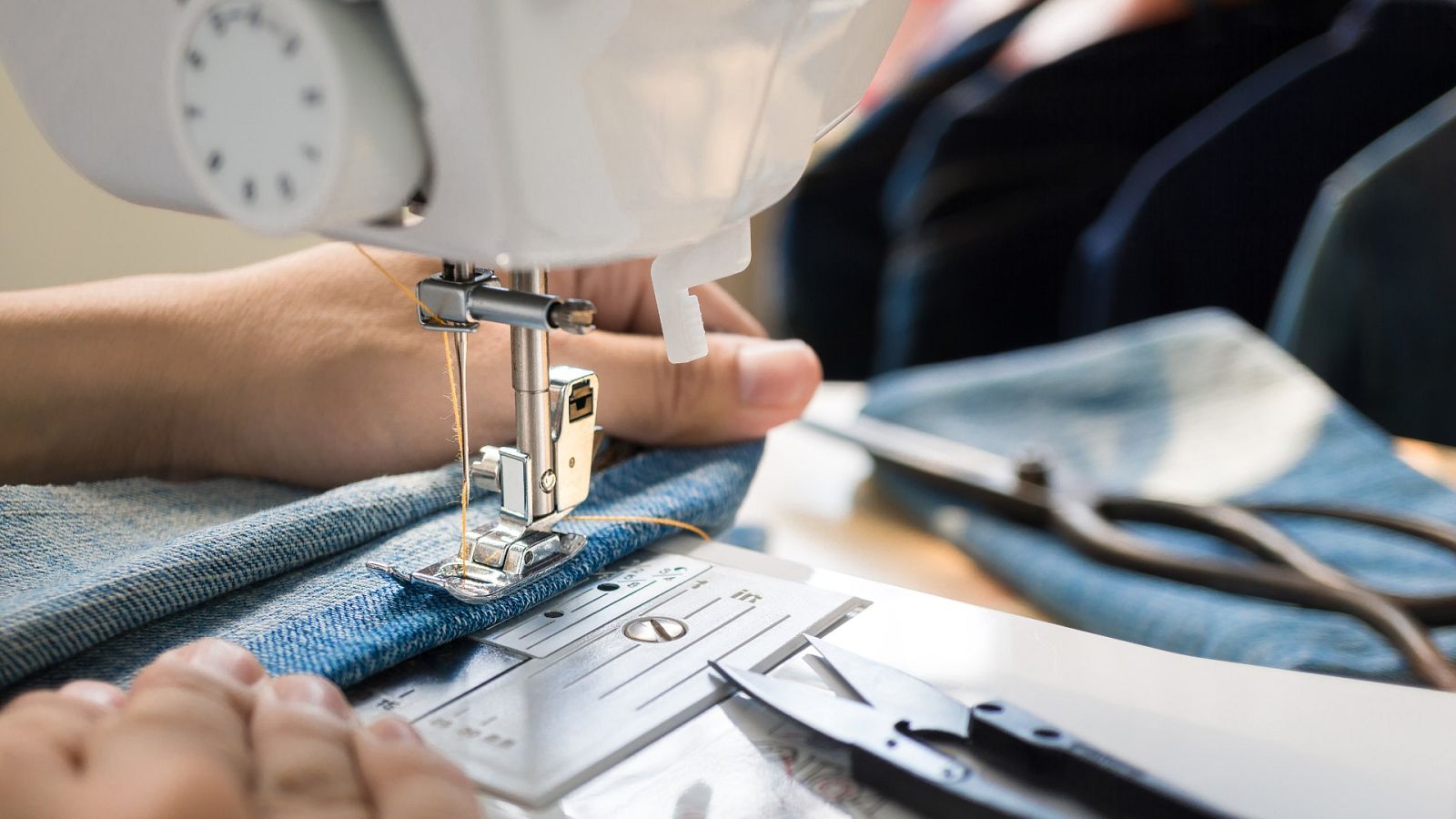 Una persona cose tela vaquera