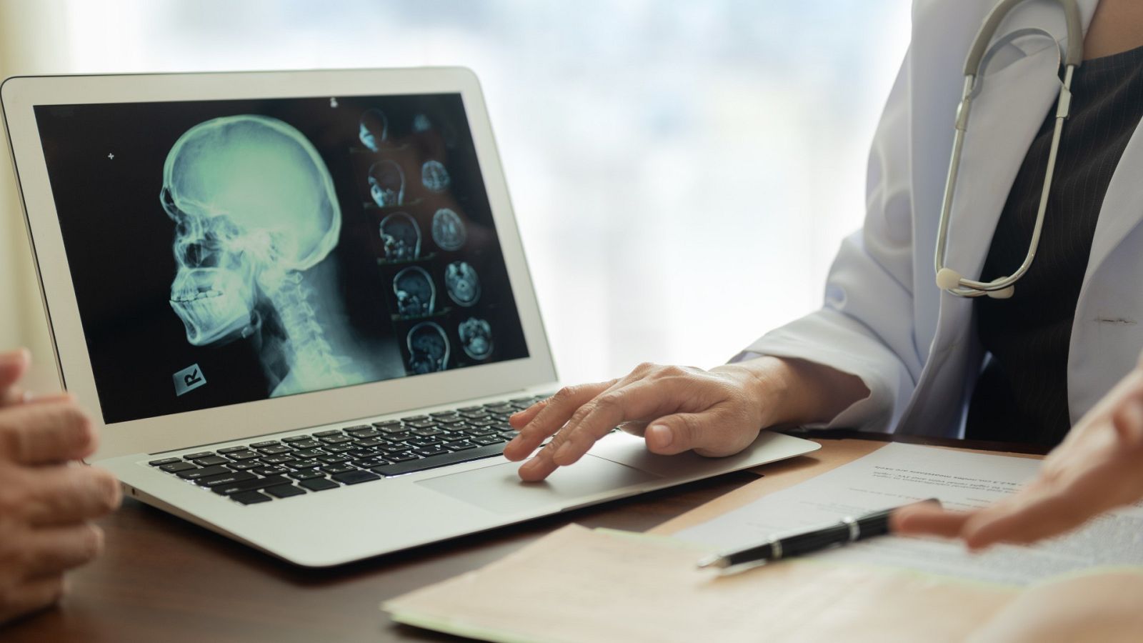 Médico y paciente revisan unas pruebas, en una imagen de archivo