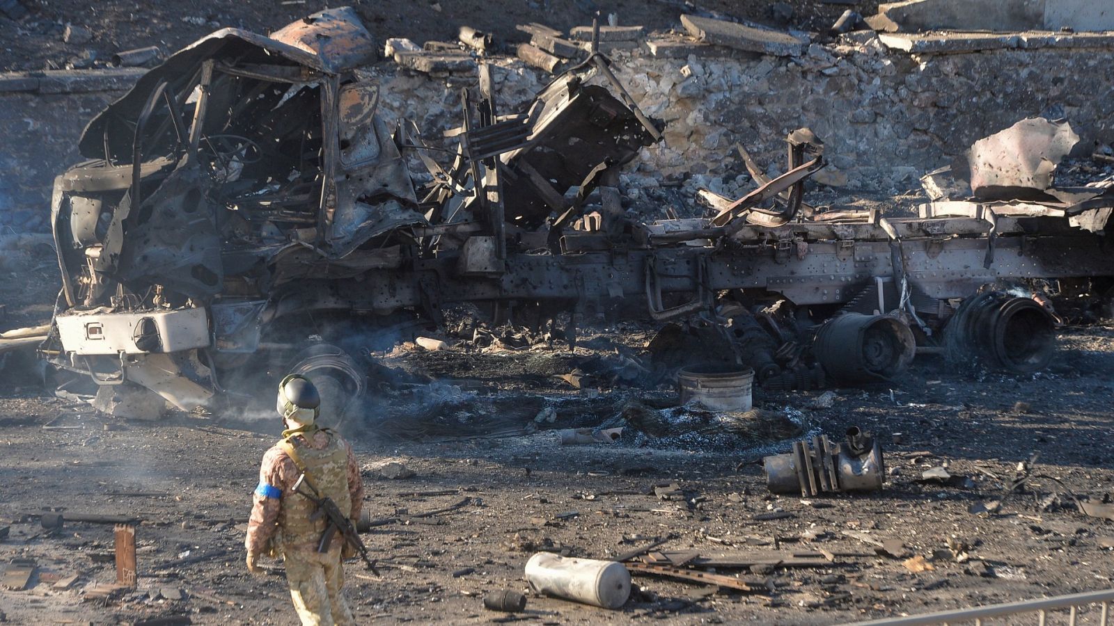 Un militar ucraniano junto a un vehículo calcinado tras los combates nocturnos en Kiev