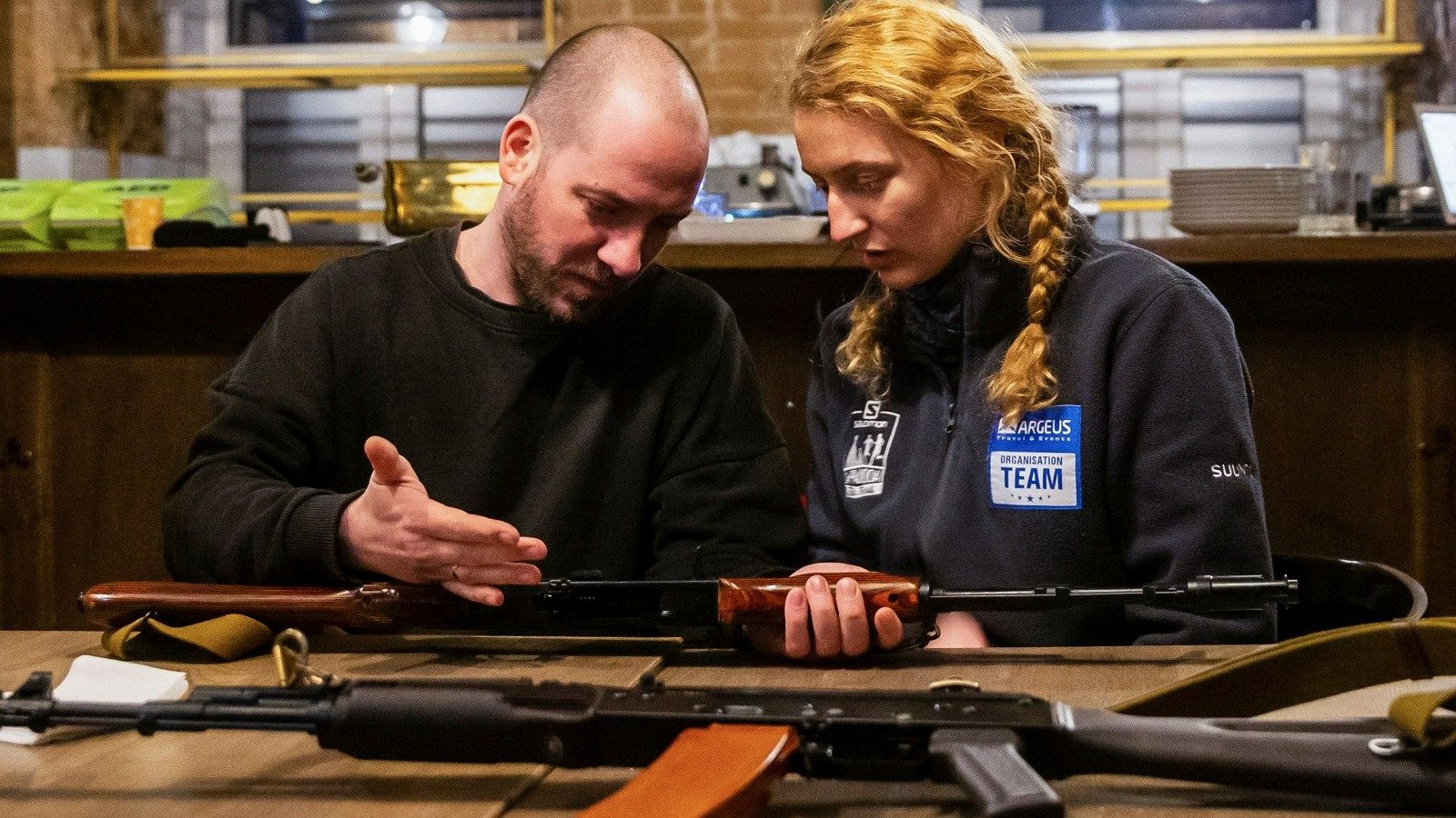 Un militar explicando el fincionamienUn militar explicando el fincionamiento de un fusil a una voluntaria to de un fusil a una voluntaria