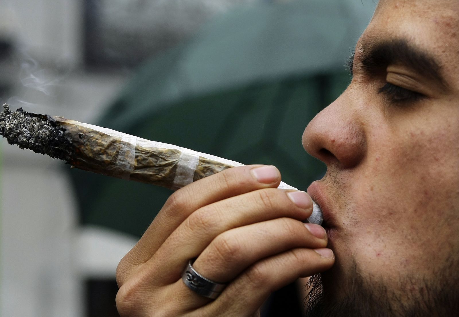 A man smokes a huge joint during a march in Madrid