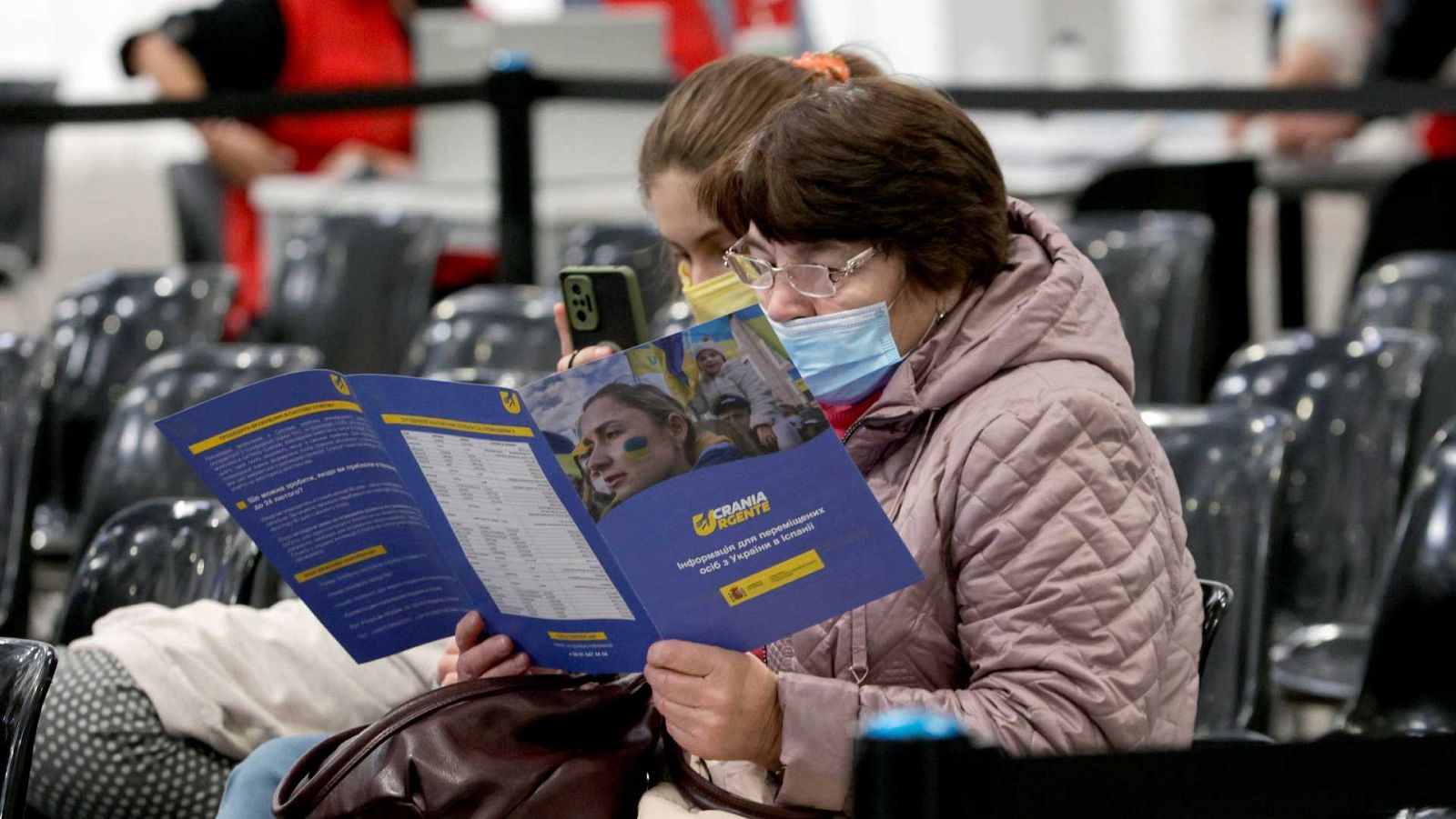 Una dona consulta la guia que s'entrega als refugiats que arriben al centre habilitat a la Fira de Barcelona