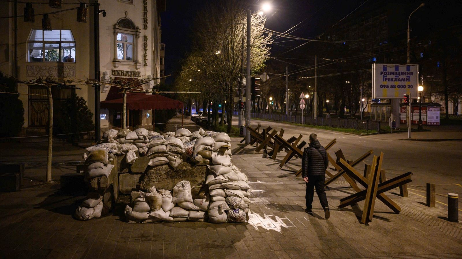 Un peatón camina por una calle entre protectores antitanque en Dnipro, Ucrania. 