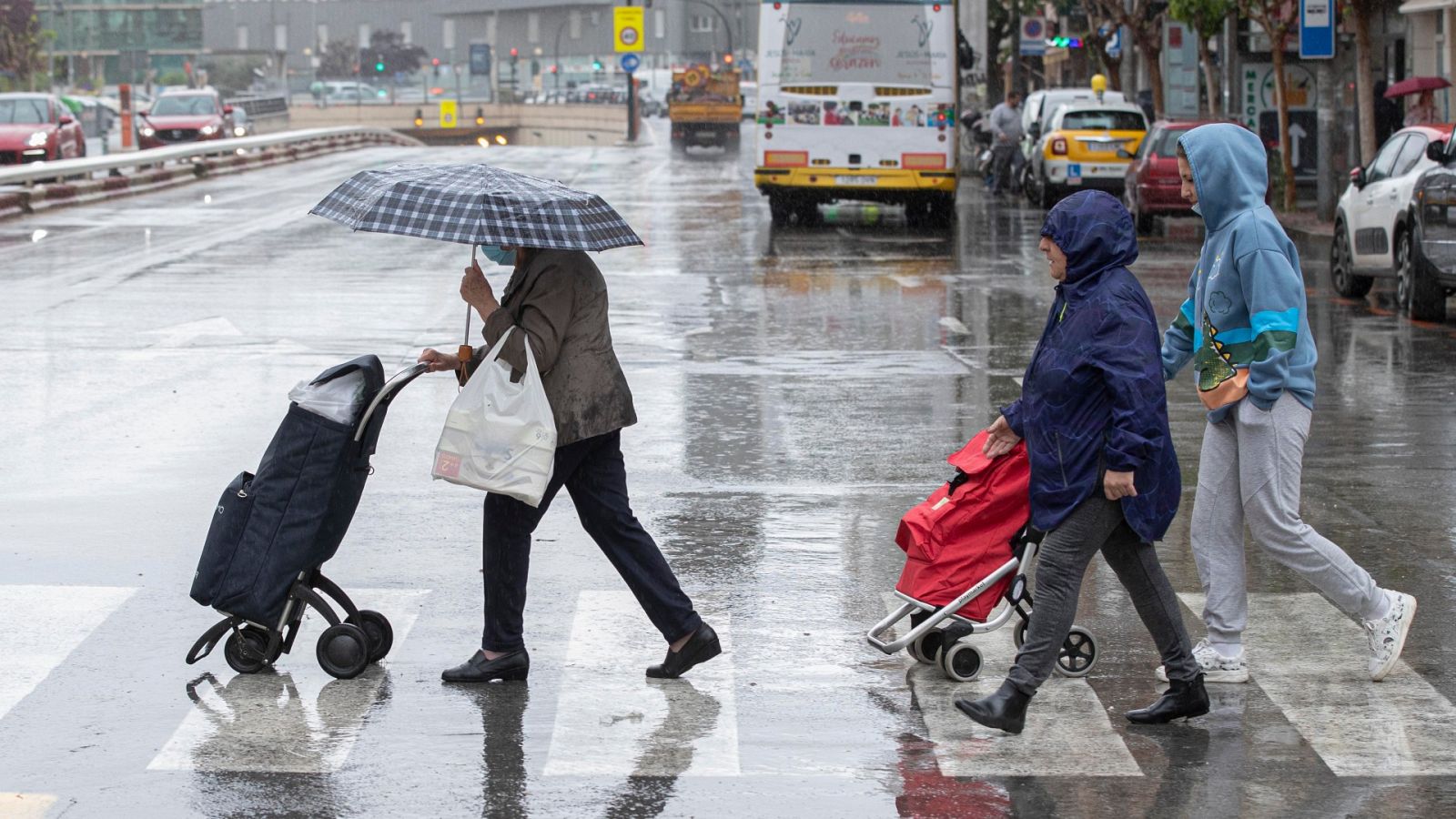Varias mujeres se protegen de la lluvia