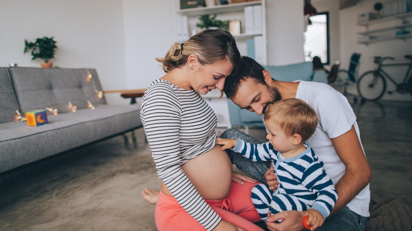Padre y madre enseñando la barriga a su hijo