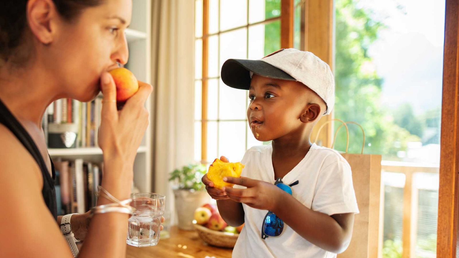 Madre e hijo comen melocotones a mordiscos