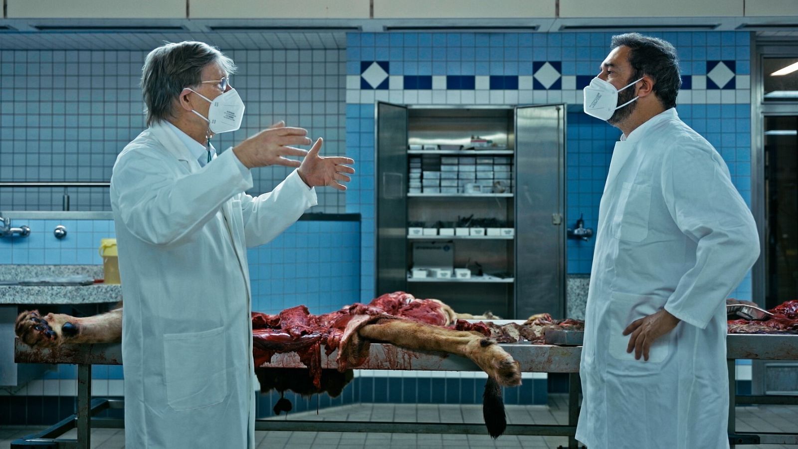 Pere Estupinyà charla con Albert Osterhaus al lado de un león diseccionado.