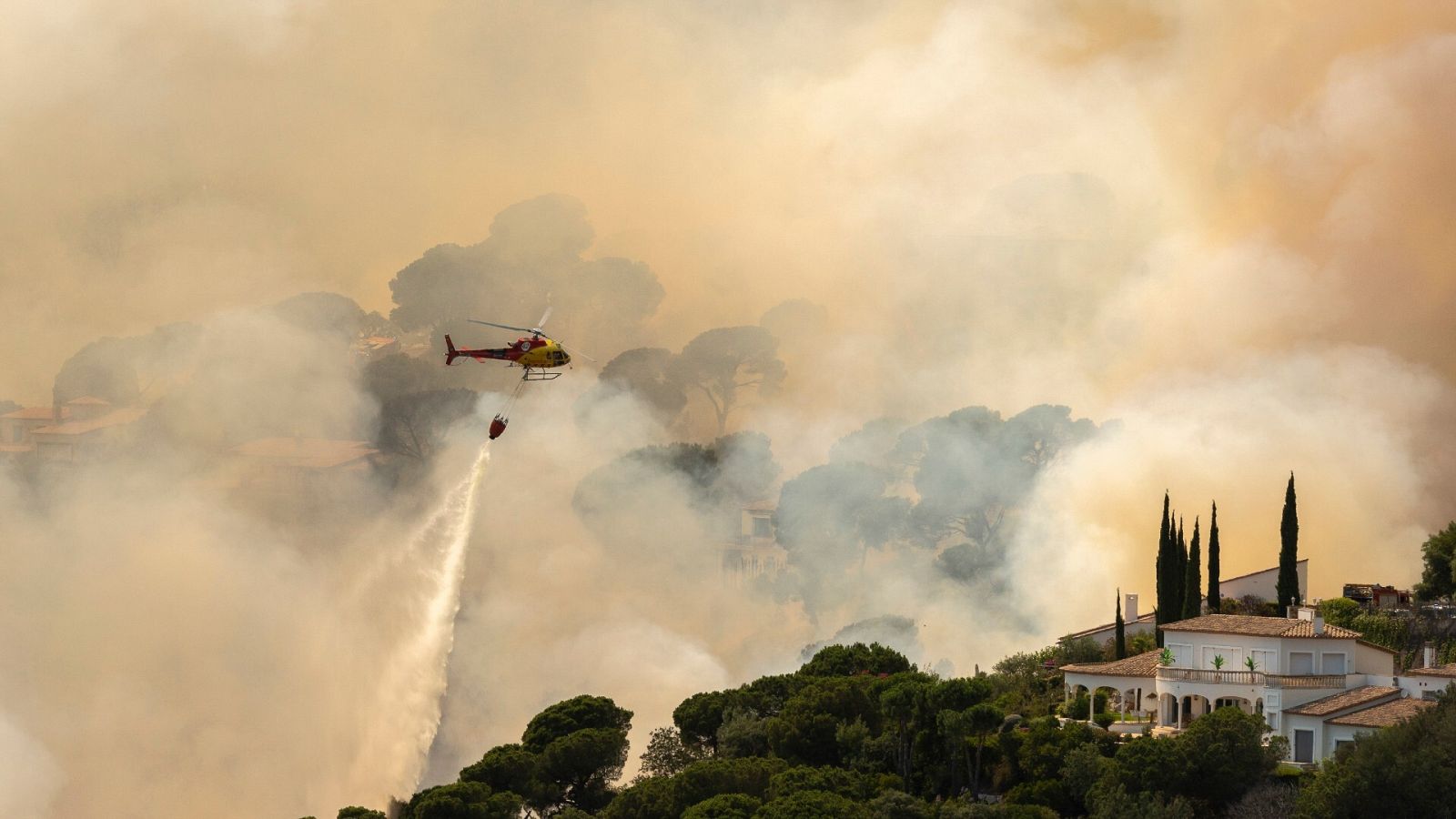 Un helicóptero trata de sofocar las llamas en Santa Cristina d'Aro