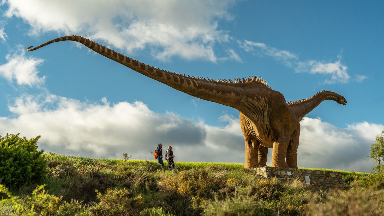 Juanjo Pardo con el guía Enrico Miracoli Romero en la réplica de apatosaurio en el Yacimiento de Miraflores de Fuentes de Magaña