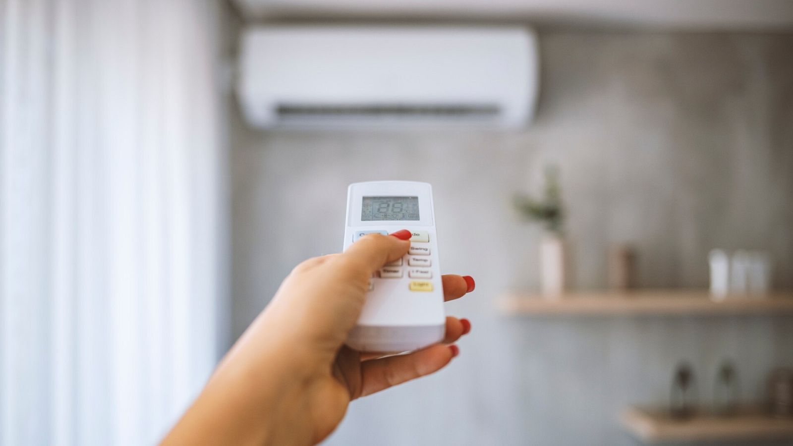 Una persona enciende un aire acondicionado