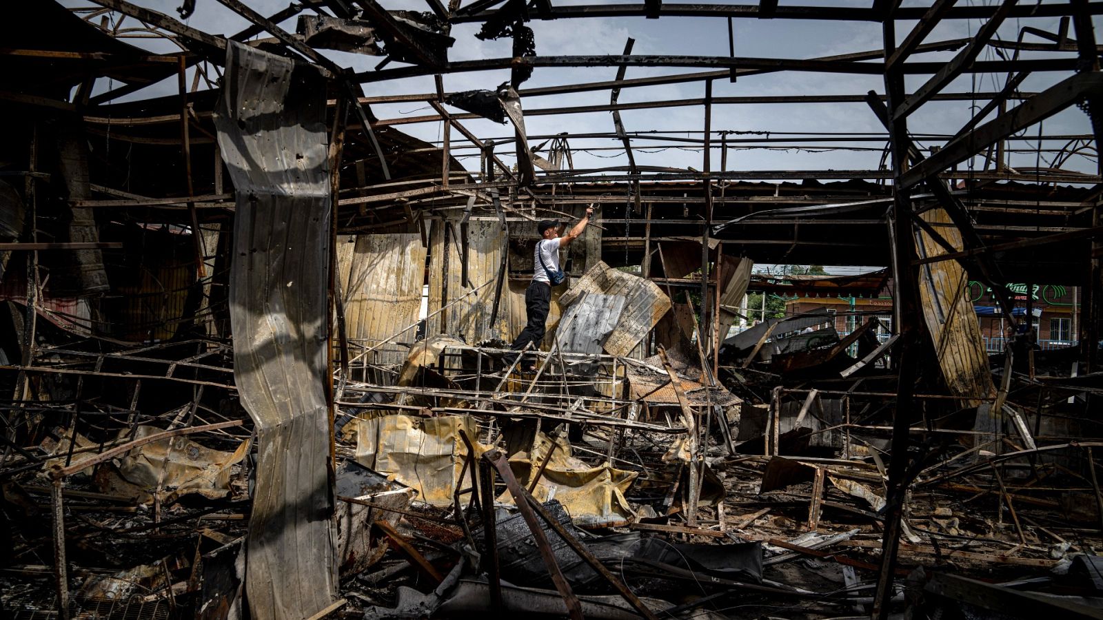 Un hombre recolecta cables en un mercado destruido el lunes en Nikopol
