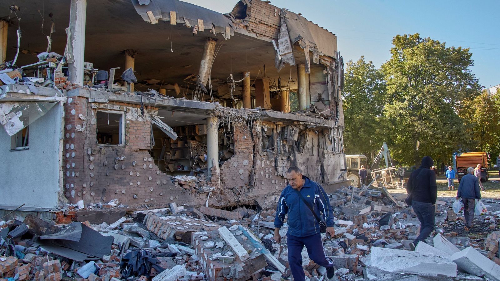 Ciudadanos pasan frente a un edificio destruido en Járkov
