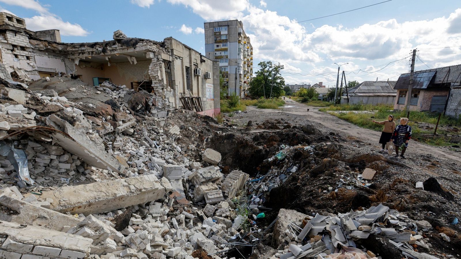 Residentes locales junto a los escombros de un edificio destruido durante el conflicto entre Rusia y Ucrania en Lisichansk
