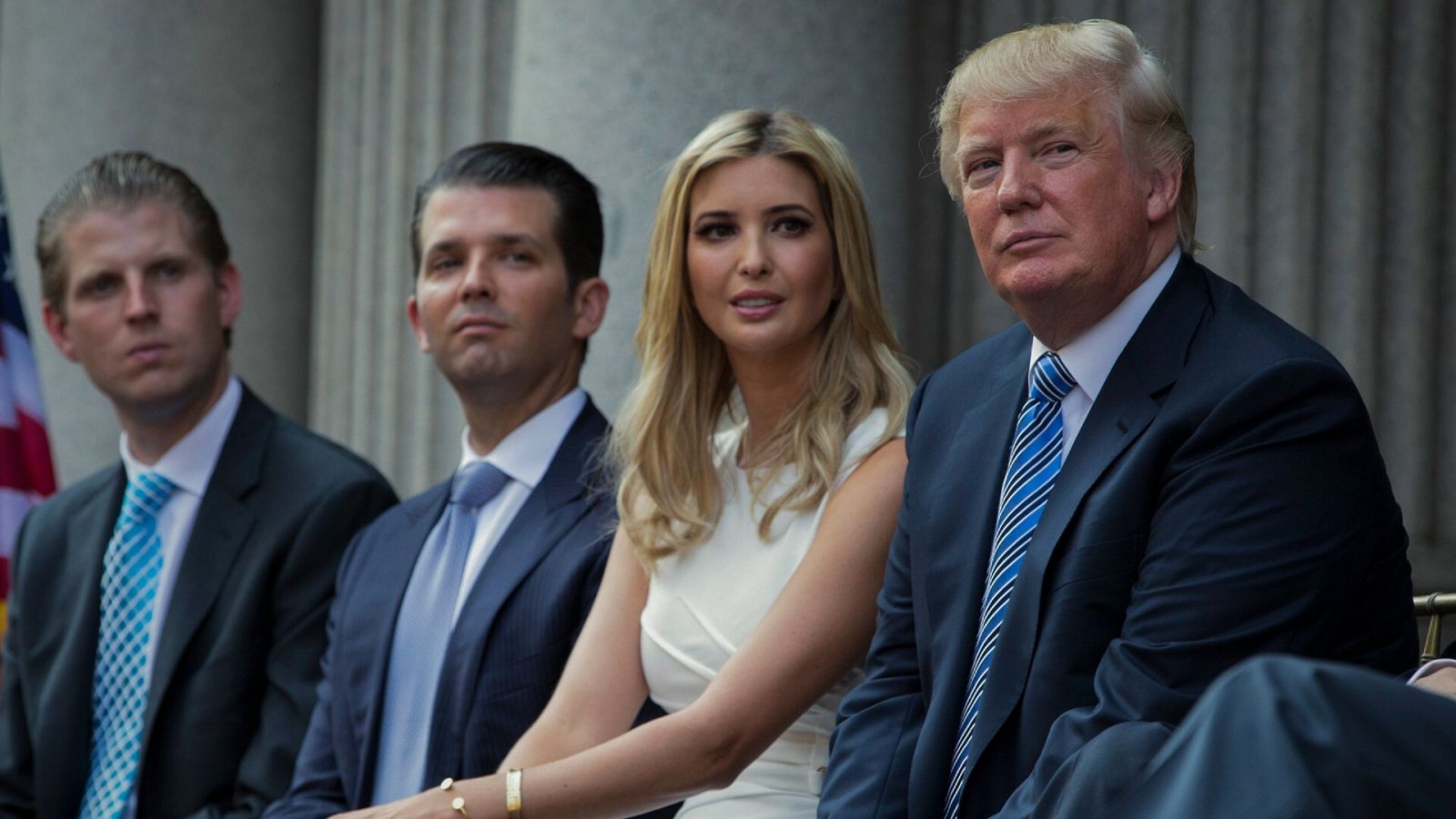 Donald Trump, sentado con sus hijos, Eric Trump, Donald Trump Jr. e Ivanka Trump