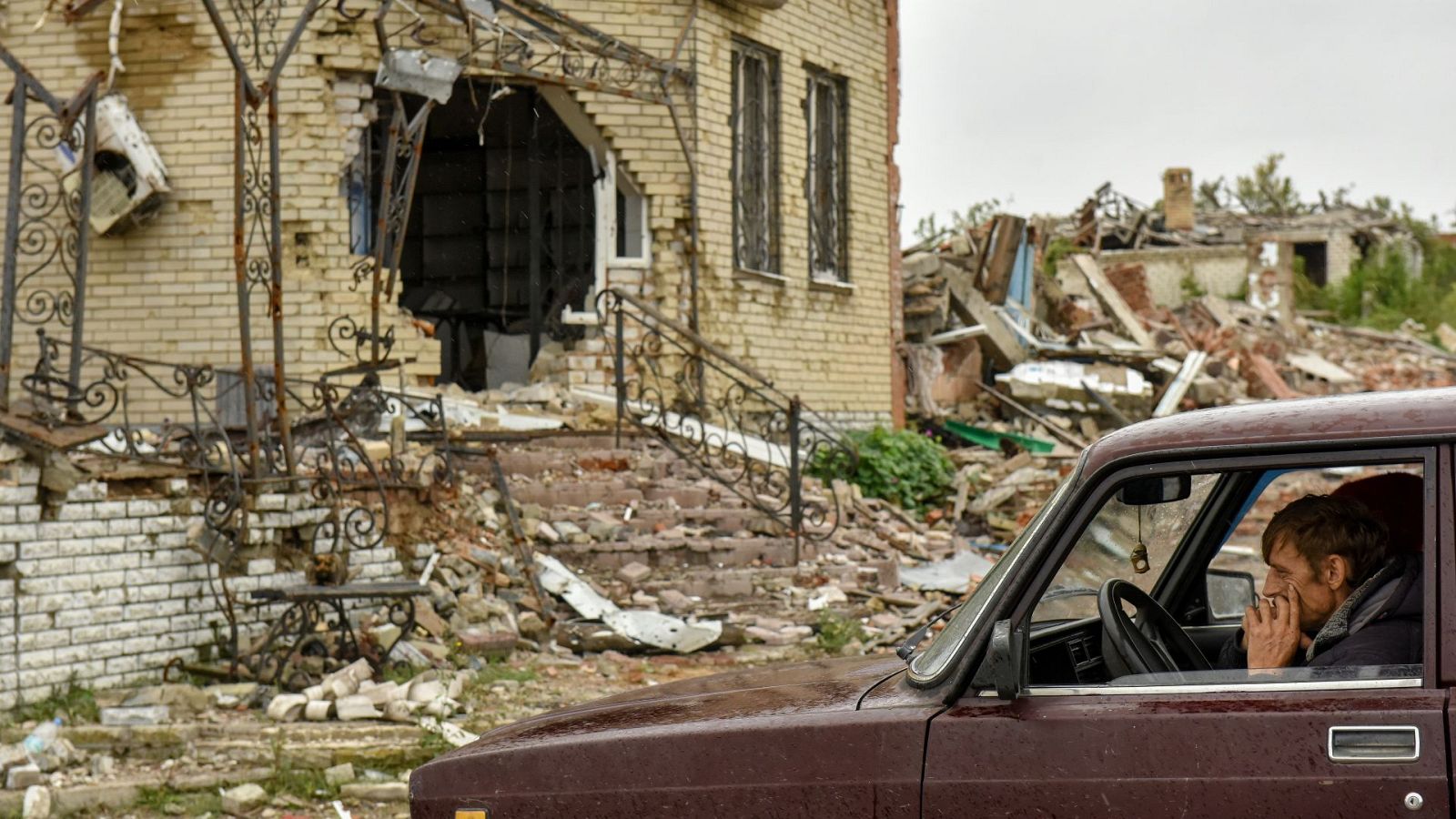 Un residente sentado en su coche en medio de la destrución por la guerra en Dolina, en Donestk (Ucrania)