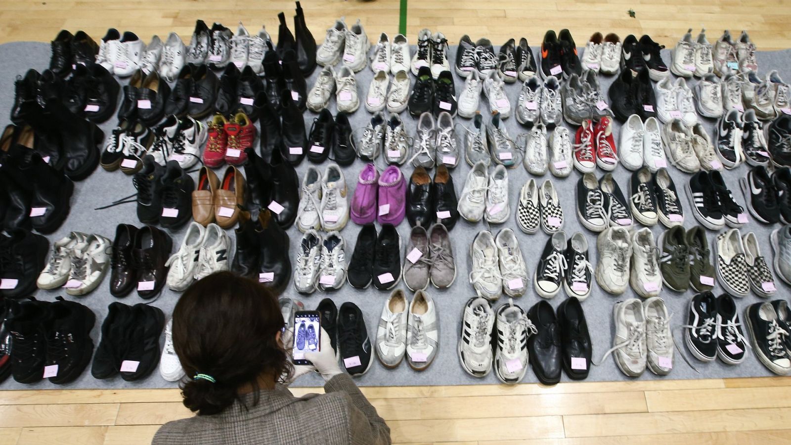 Una policía comprueba los zapatos de las víctimas de la estampida que se produjo durante la celebración de Halloween, en Seúl