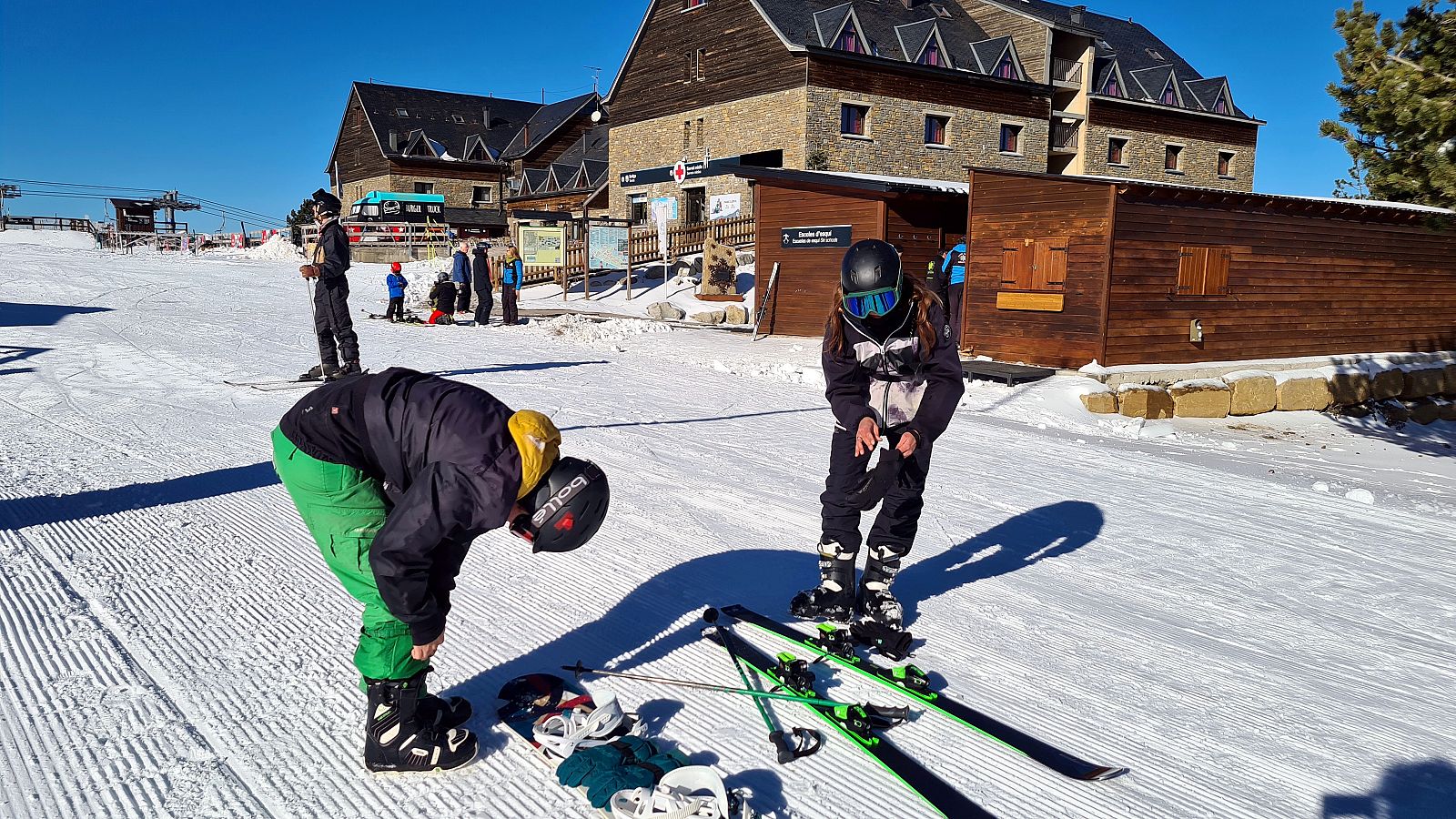 Dos esquiadors preparant-se per iniciar una jornada d'esquí a Port Ainé