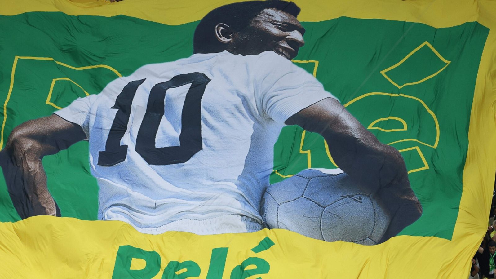 Una imagen de Pelé en una bandera gigante de Brasil durante un partido del Mundial.