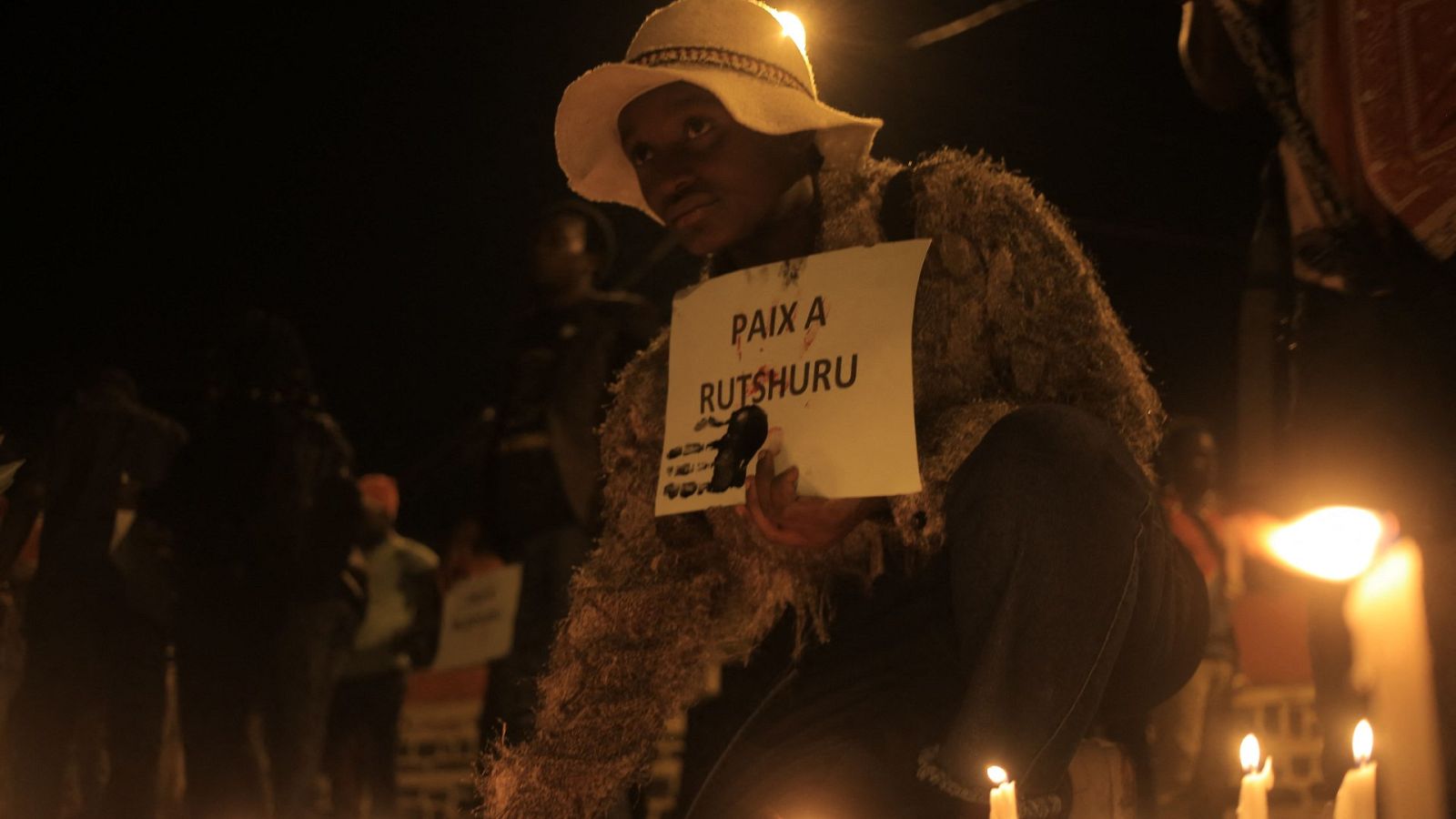 Una mujer coloca una vela en Beni durante una vigilia en recuerdo de las víctimas en el este del país