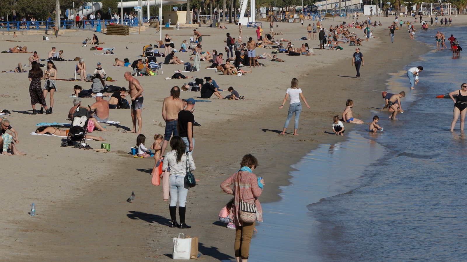 Un gran número de personas disfrutan del buen tiempo en la playa de El Postiguet de Alicante durante la mañana de este jueves