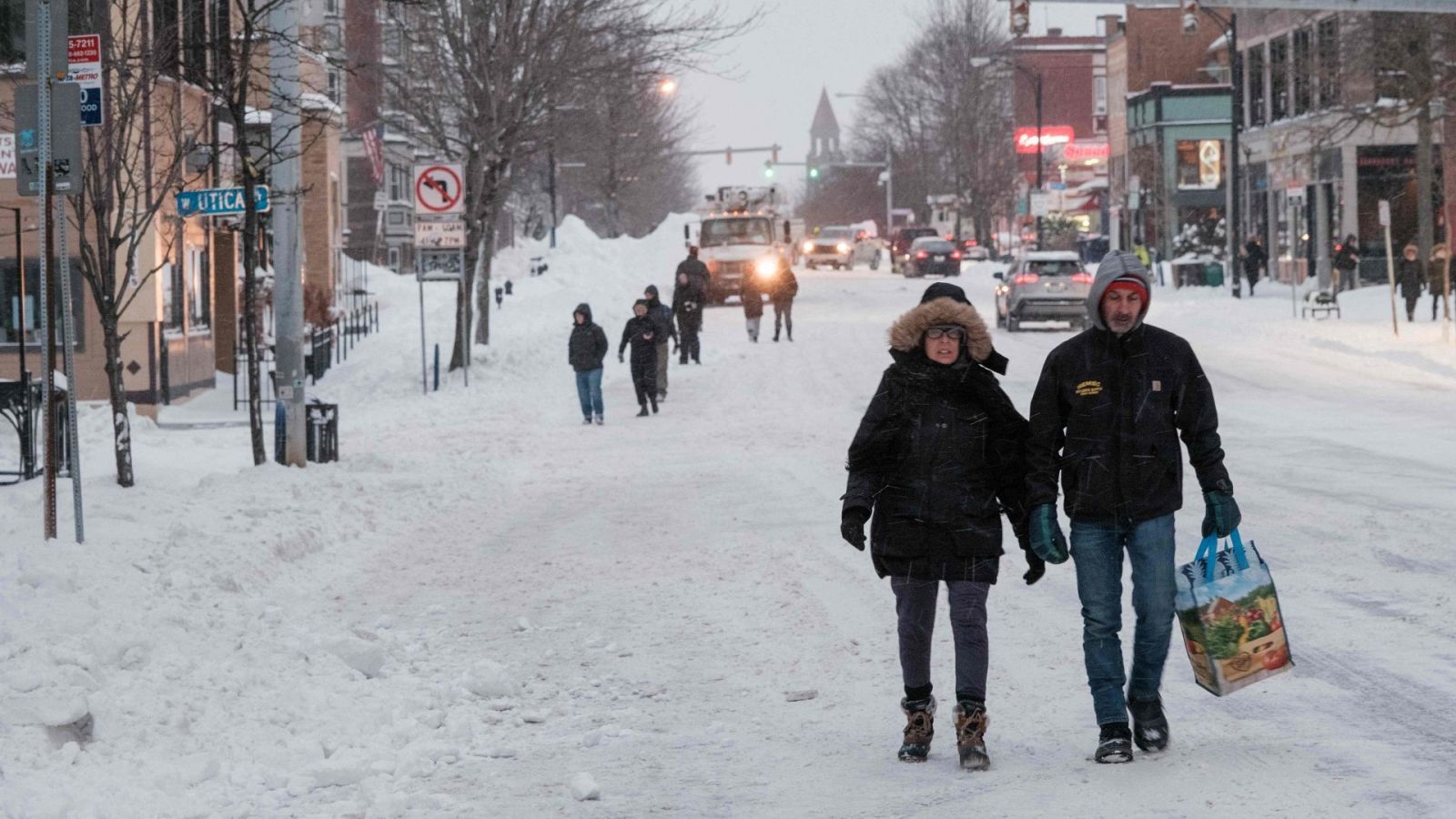 Varias personas caminan por una calle cubierta de nieve en Búfalo, en el estado de Nueva York