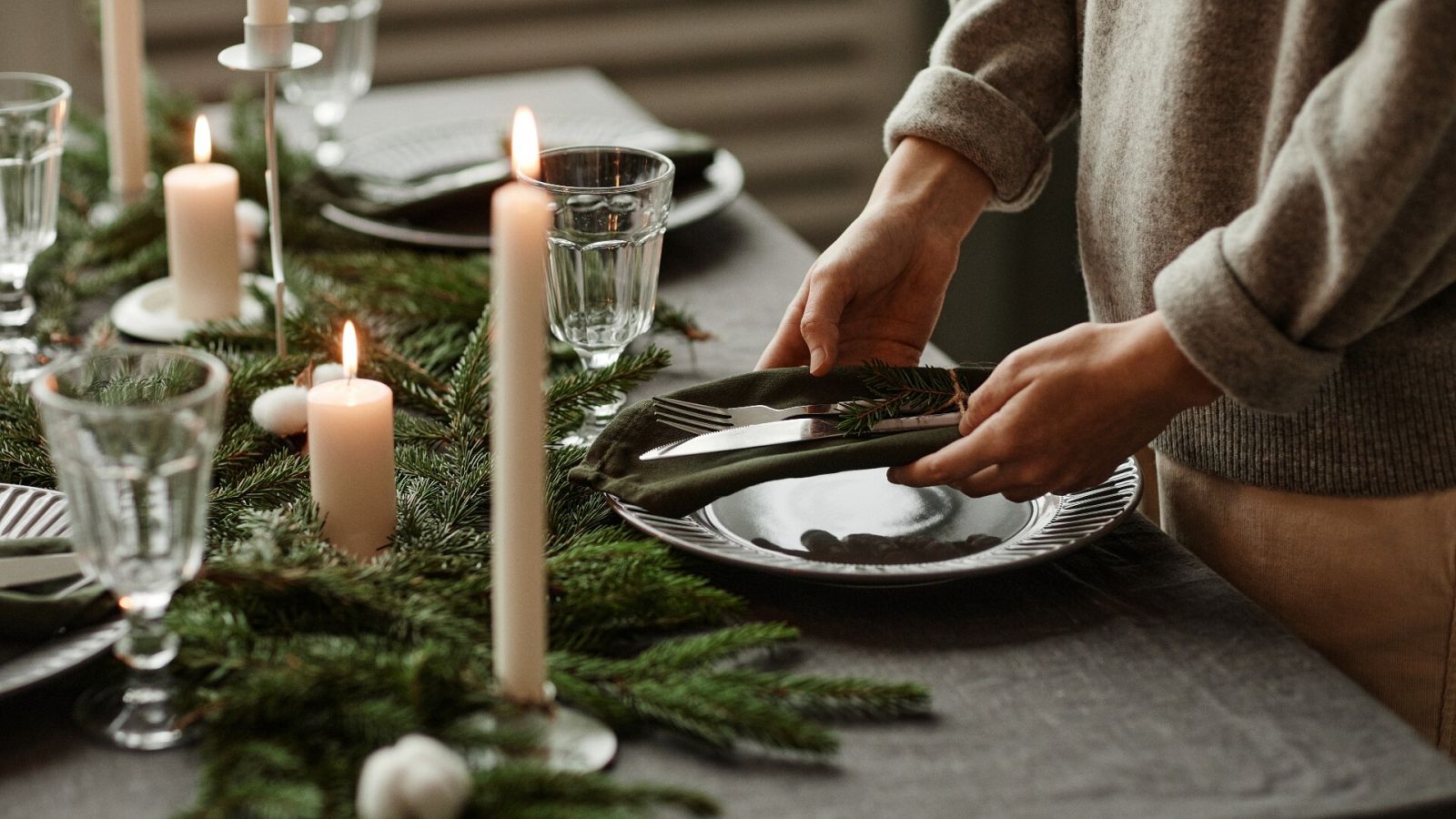 Una persona coloca los cubiertos en la mesa antes de una comida familiar