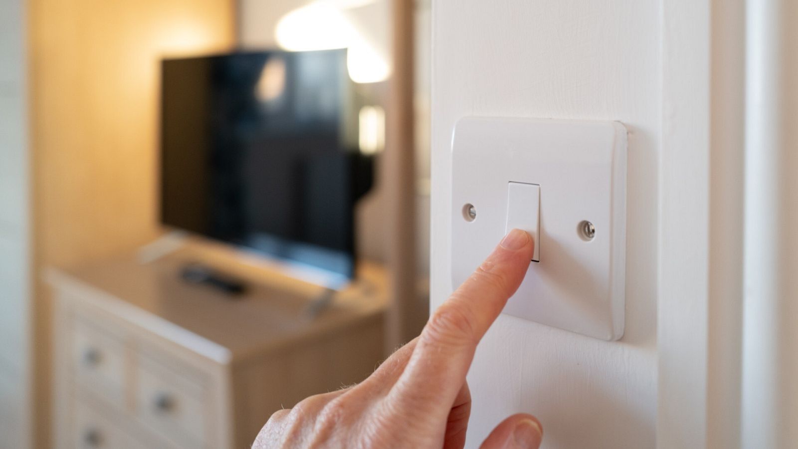Una persona apaga la luz de una habitación