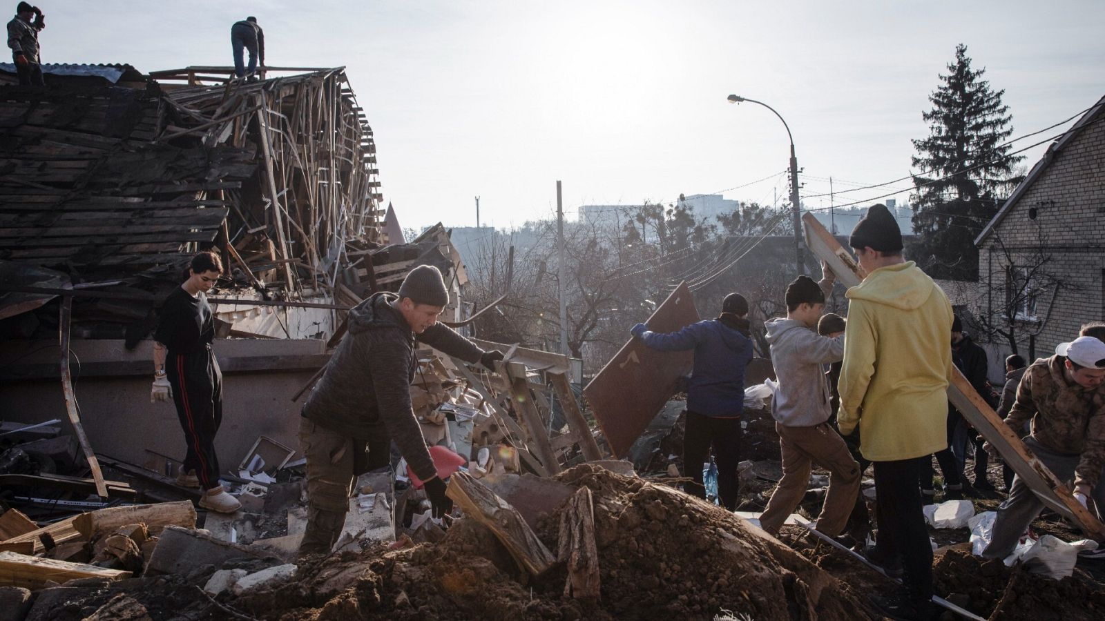 Voluntarios retiran los escombros tras un ataque ruso en Kiev