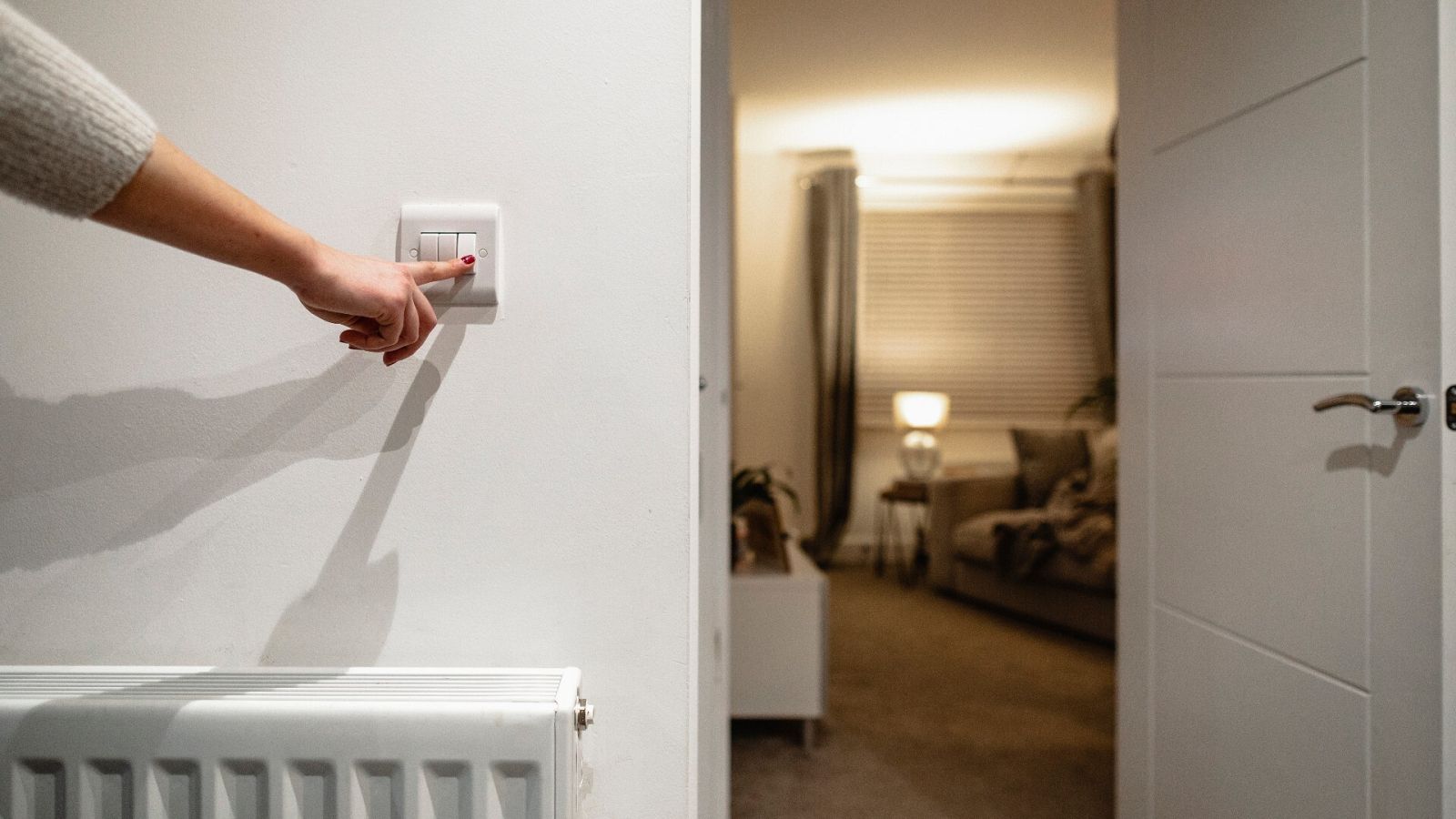 Una mujer apaga la luz en el salón de su casa