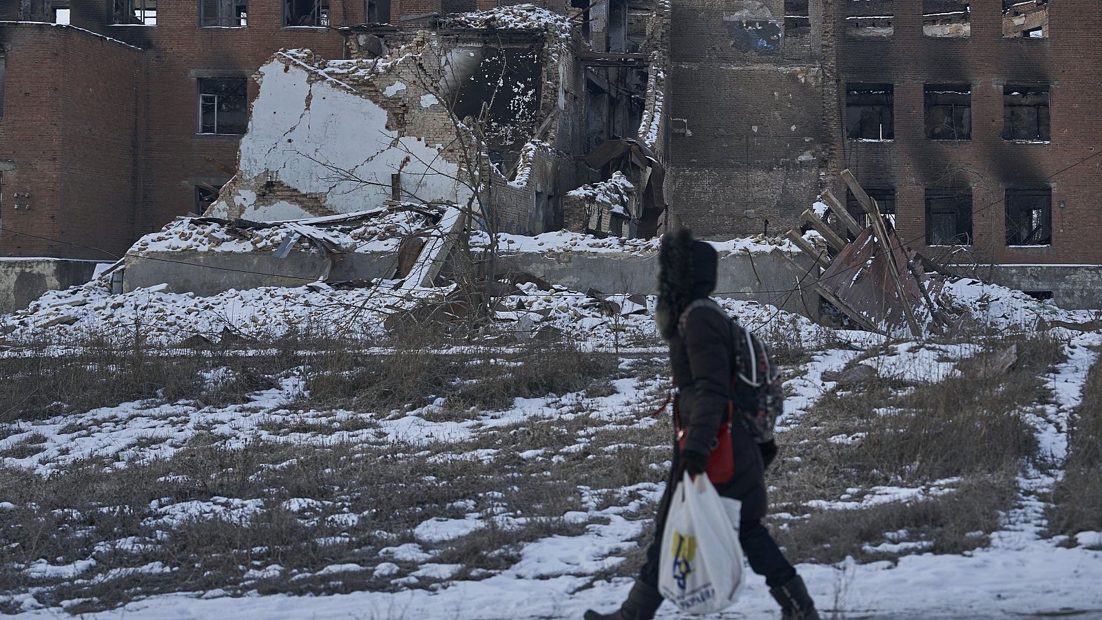 Una mujer pasa delante de un edificio destrozado por la guerra en Donetsk