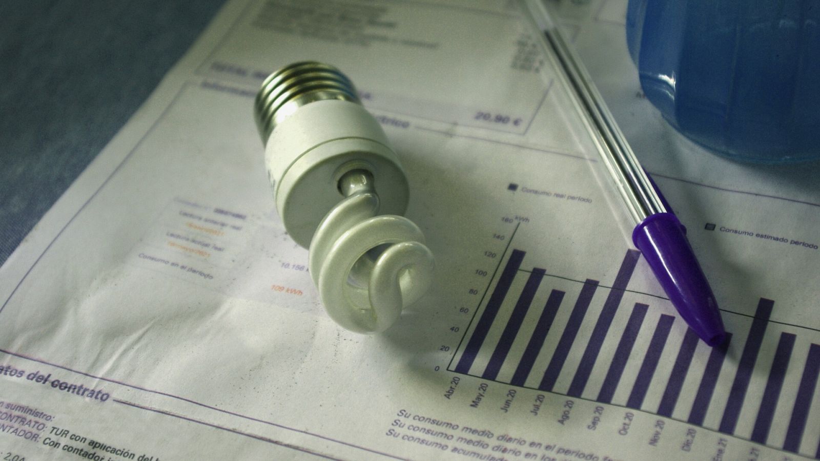 Una bombilla encima de una factura de electricidad