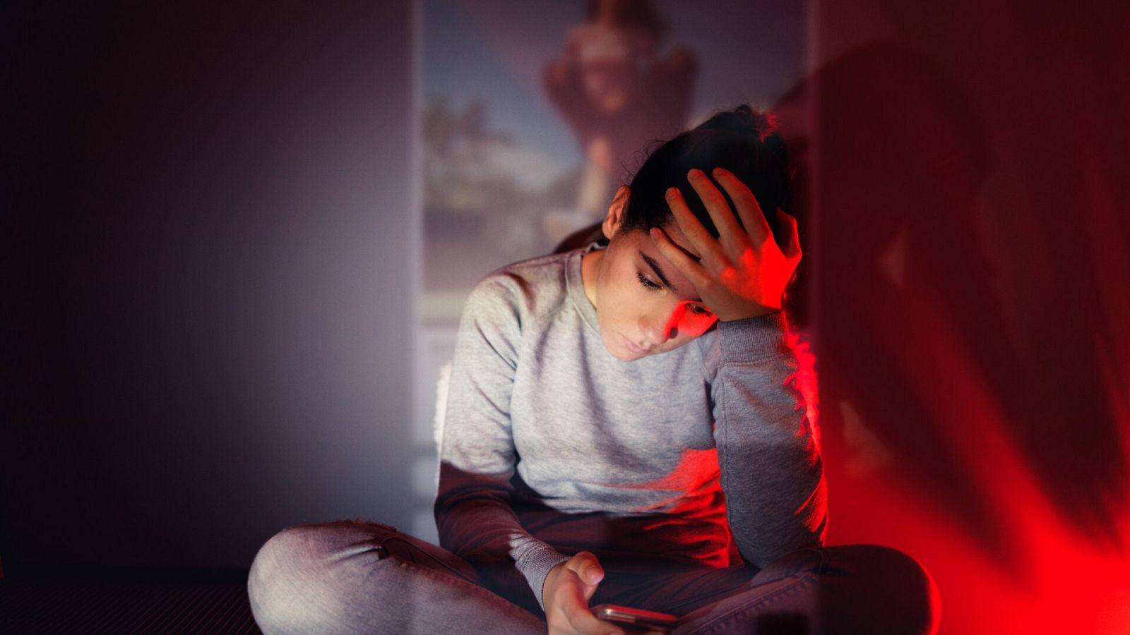 Una mujer joven observa preocupada una fotografía en su móvil